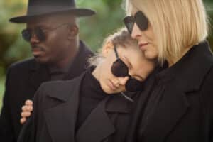 Academic Approach Tutoring and Test Prep | A group of people in black coats and hats are hugging a woman.