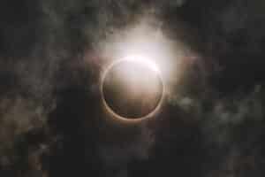 Academic Approach Tutoring and Test Prep | Solar eclipse with a dramatic corona visible through clouds.